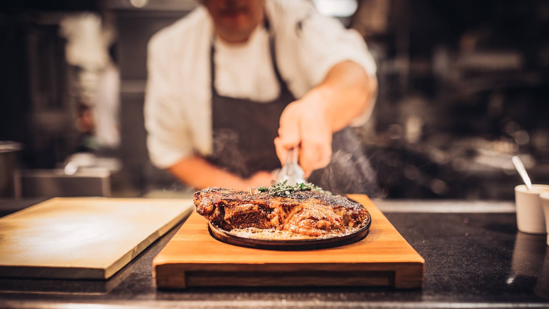 Chef serving meat on a plate